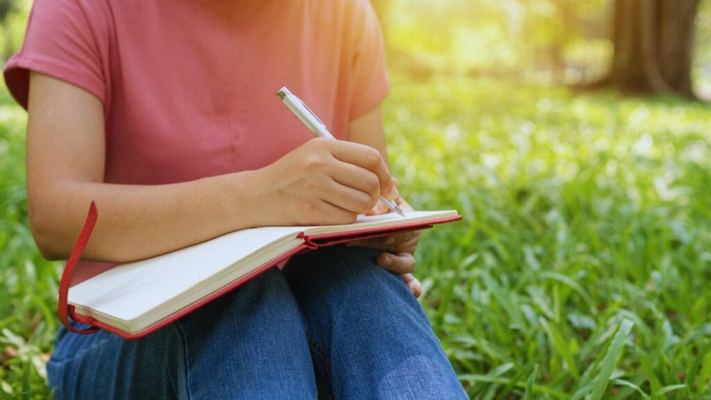 Woman writing a poem on the grass